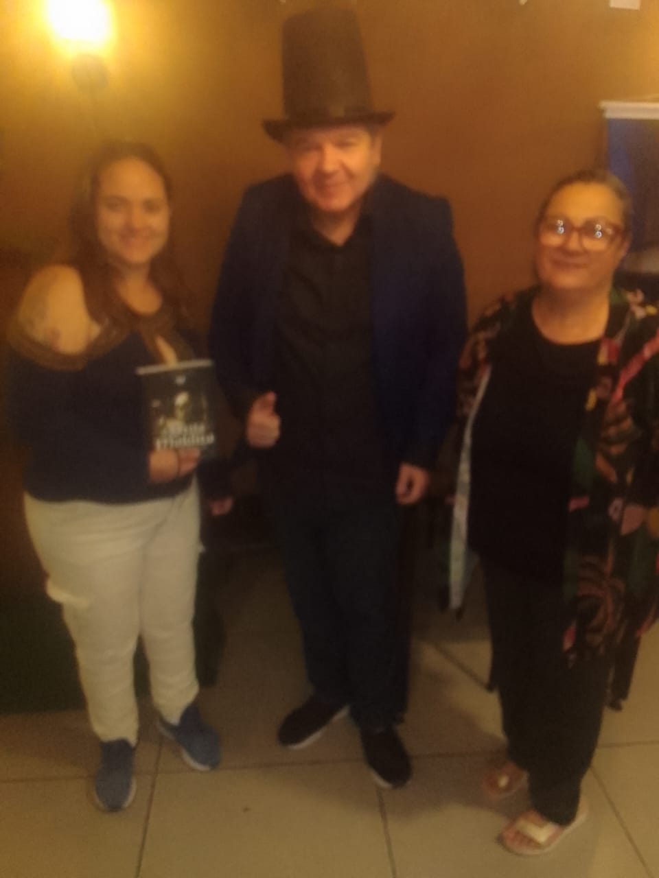 J. Angelini de cartola com duas leitoras no lançamento de A Seita Maldita