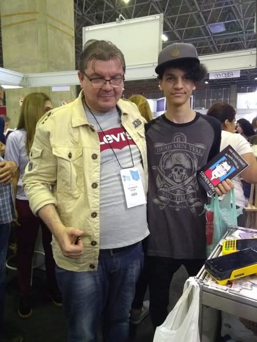 J. Angelini com leitor em evento literário