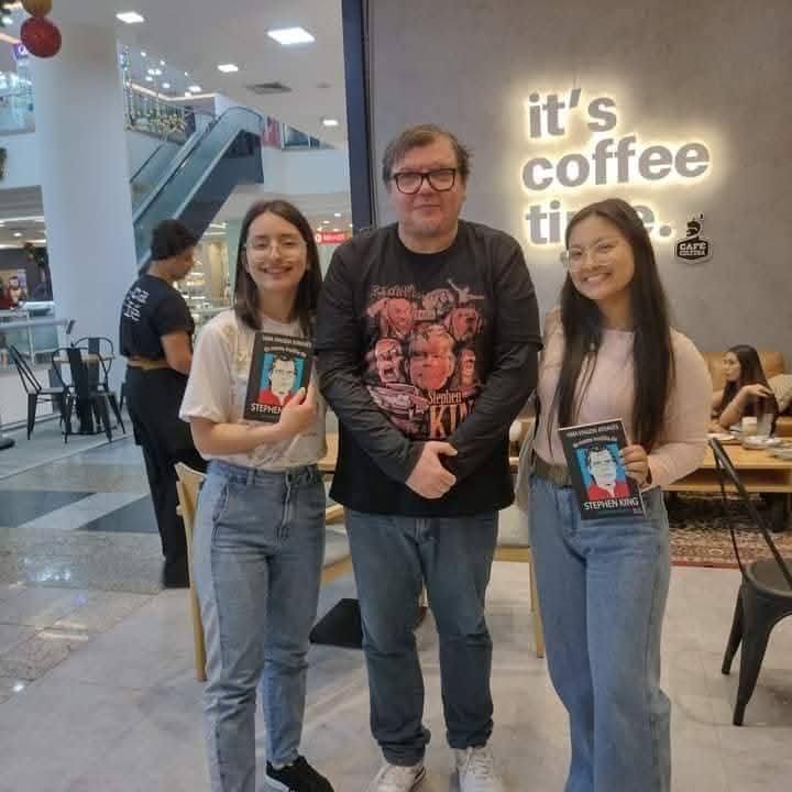 Leitores com a biografia de Stephen King em cafeteria