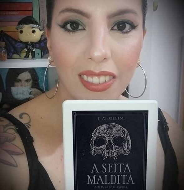homem de capuz preto com cajado e abóbora de Halloween no cemitério