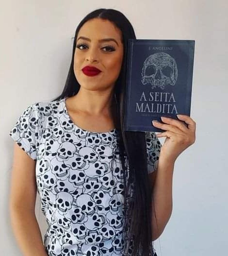 autora segurando seu livro de horror A Seita Maldita
