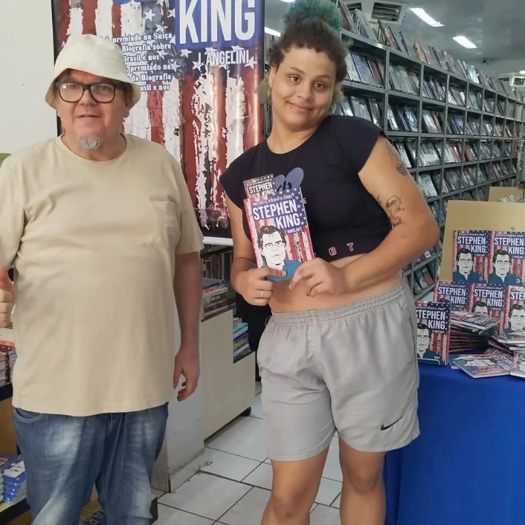 autor em lançamento do livro sobre Stephen King em livraria, ao lado de leitora