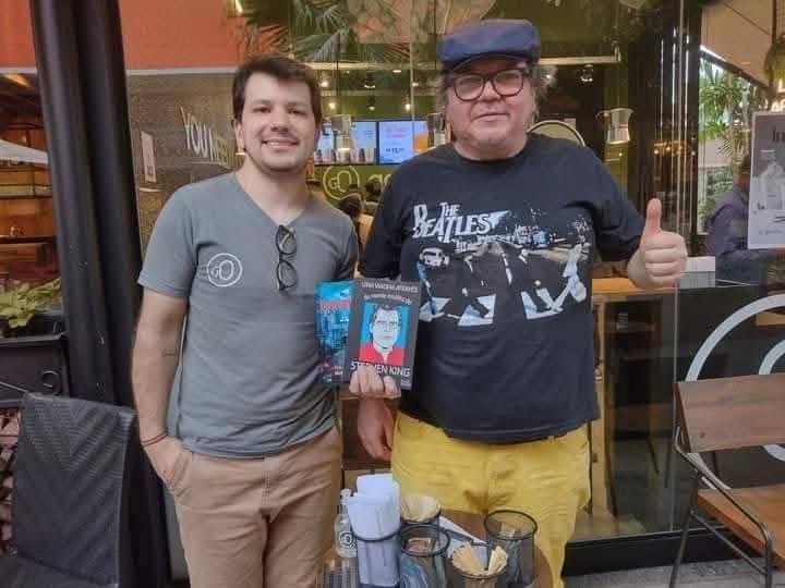 autor exibindo seu livro Sweeney Todd em evento de lançamento em cafeteria