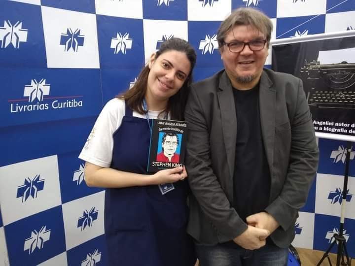 autor em evento literário na Livrarias Curitiba com seu livro sobre Stephen King, ao lado de máquina de escrever
